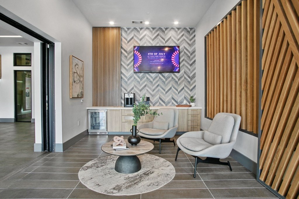 a lobby with two chairs and a table with a vase on top of it
