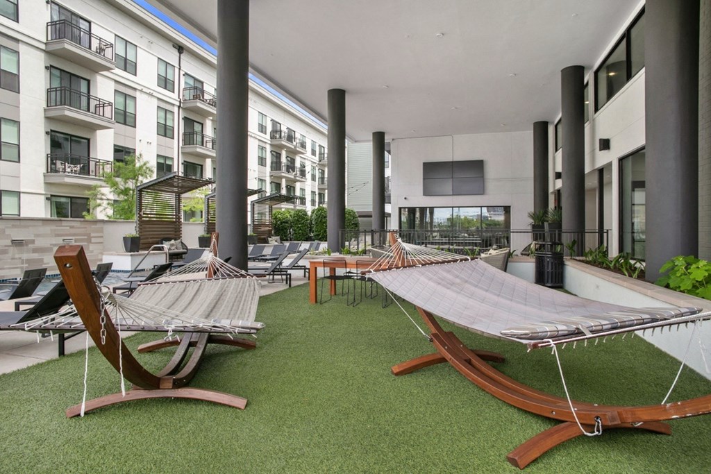 an outdoor lounge area with hammocks and lounge chairs