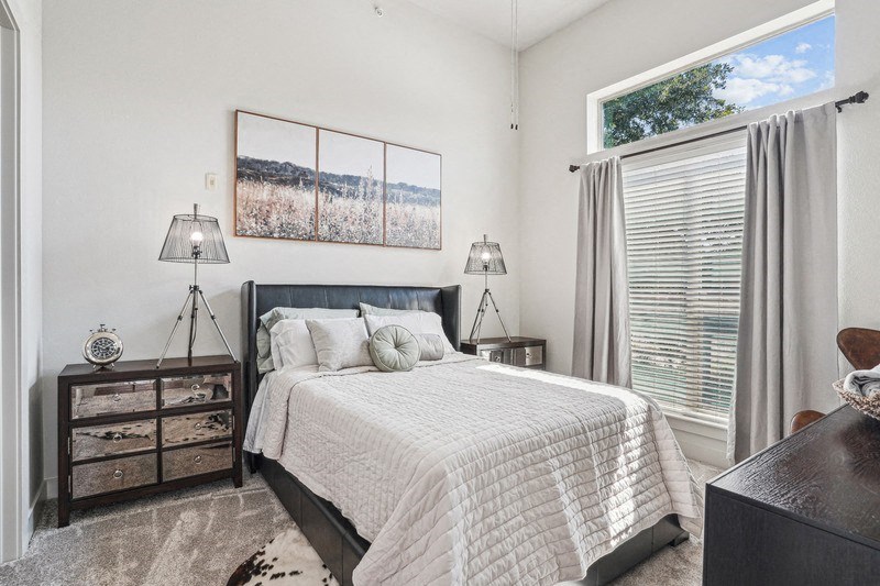 a bedroom with a bed and a large window