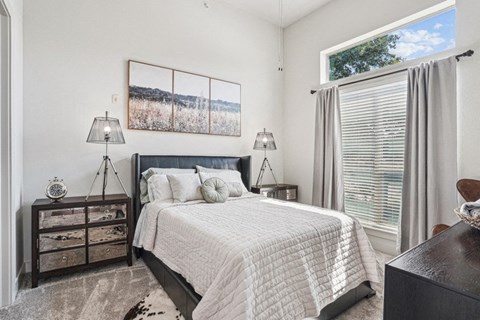 a bedroom with a bed and a large window