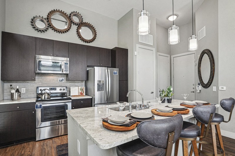 A modern kitchen with a dining table set for two.