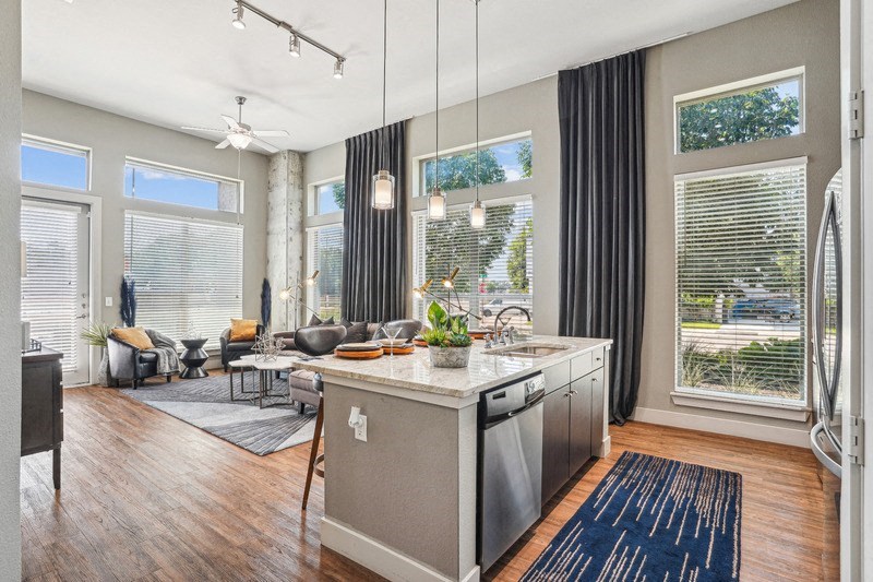 the living room and kitchen of an apartment with a large window