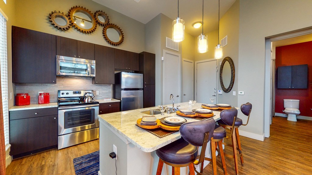a kitchen with stainless steel appliances and a table with plates