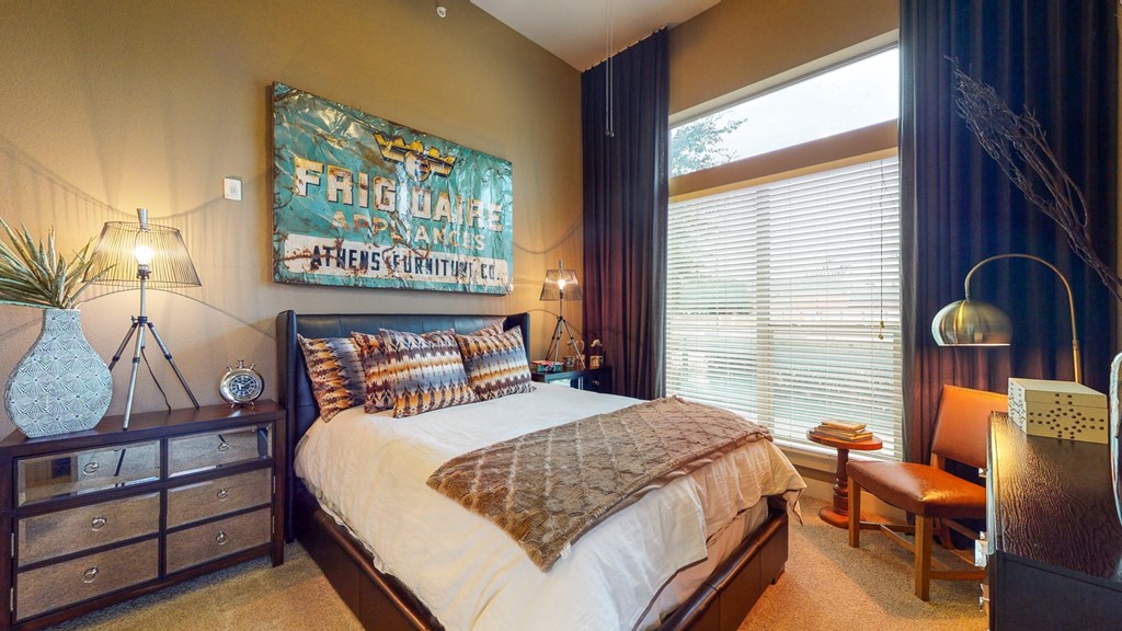 a bedroom with a bed and a painting on the wall