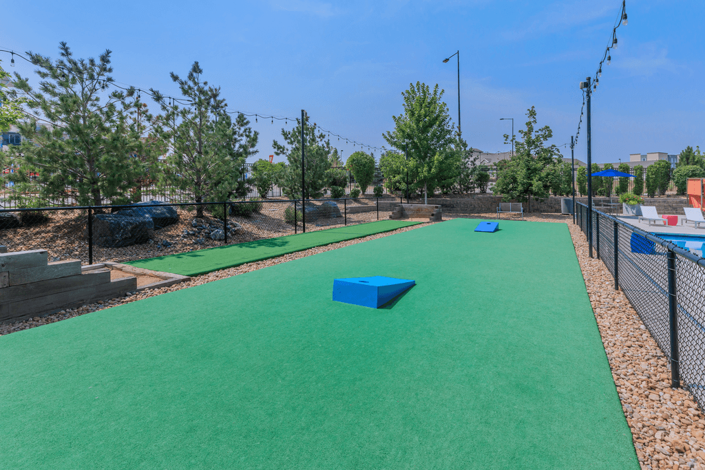 A green artificial turf area with a blue object in the middle.
