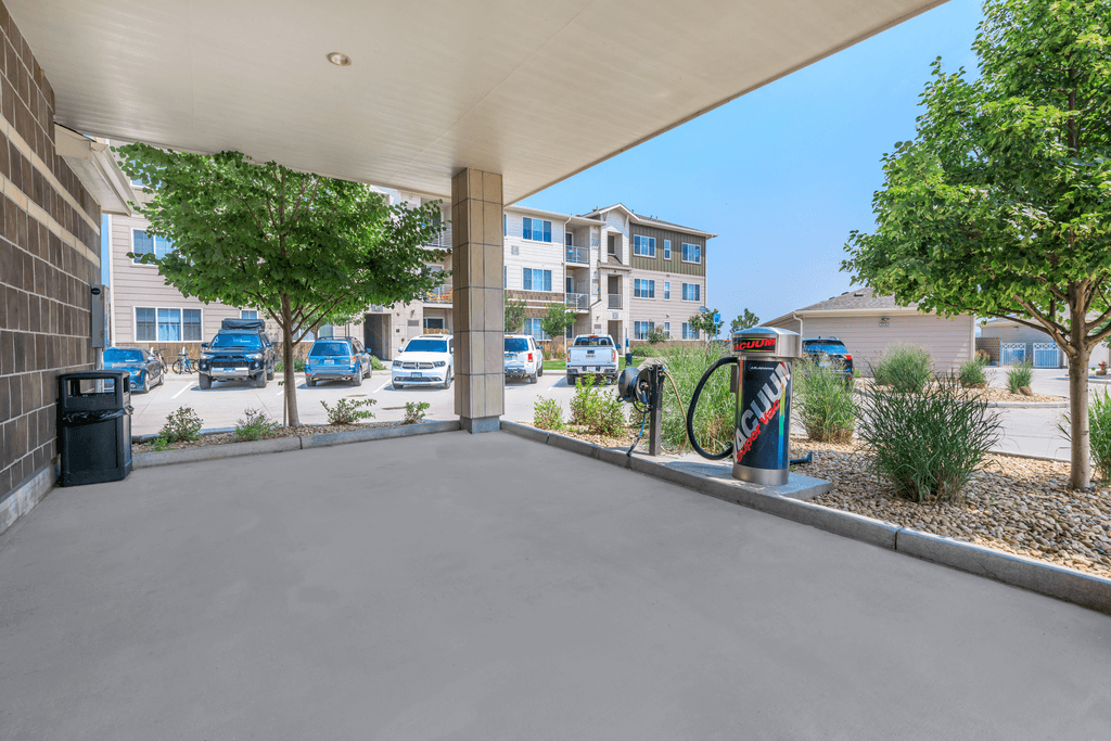 A parking lot with cars and apartment buildings in the background.
