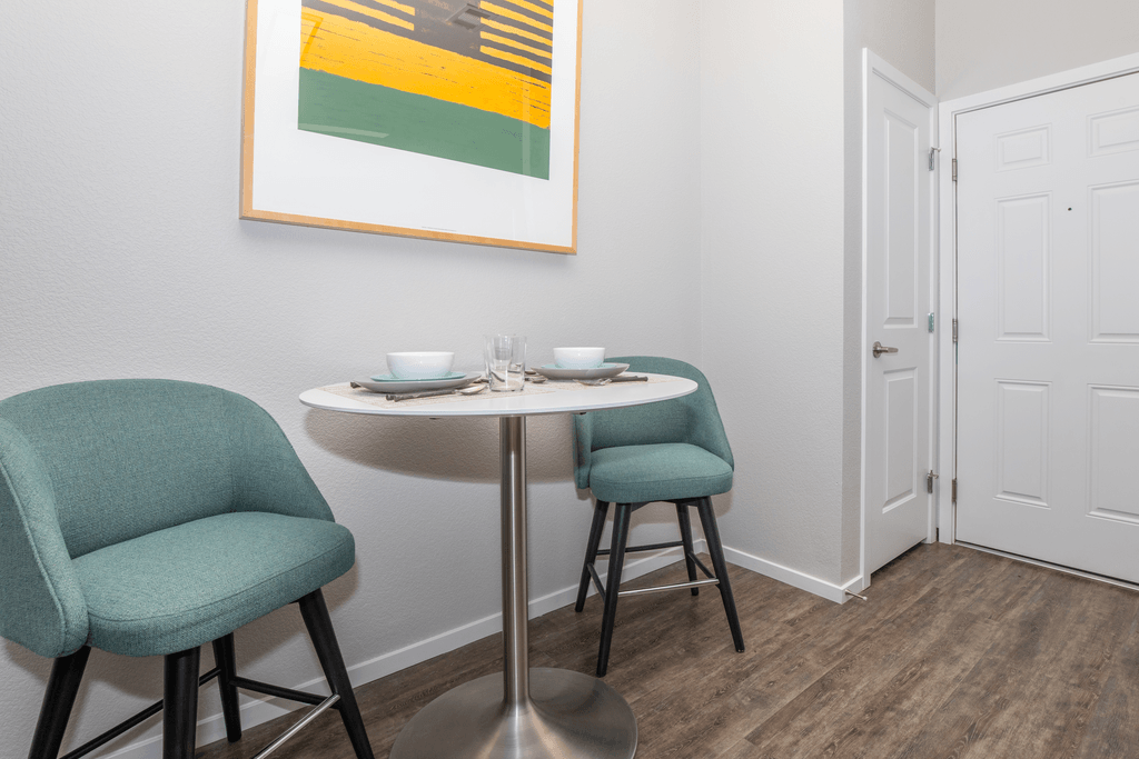 A dining table with two chairs and a bowl on it.