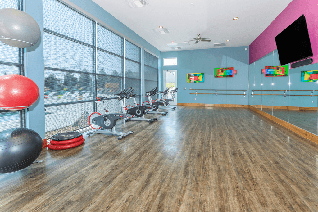 A gym with exercise equipment and a large window.