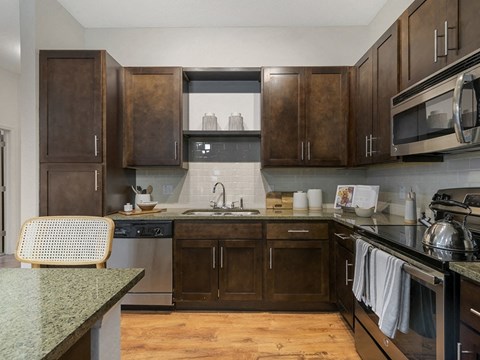 a kitchen with wooden cabinets and a sink and a stove