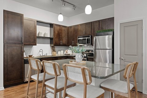 A kitchen with a table and chairs.