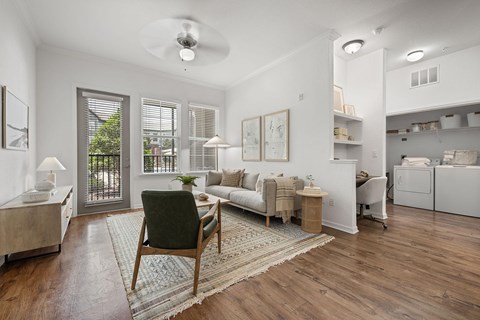 A living room with a green chair and a rug in the middle.