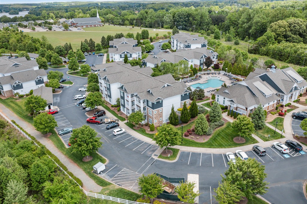 an aerial view of a large community with a swimming pool and parking lot