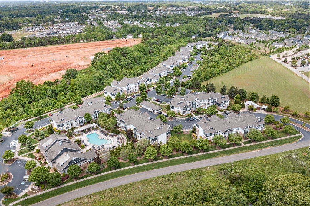an aerial view of a subdivision with a swimming pool and trees