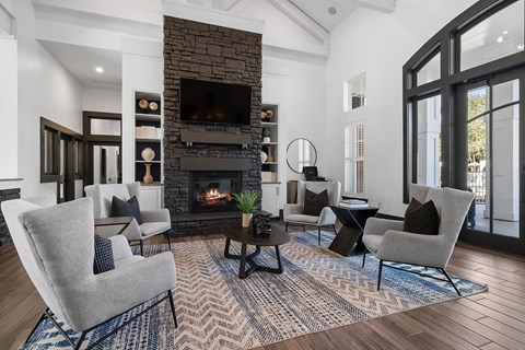 A living room with a fireplace and a grey chair.