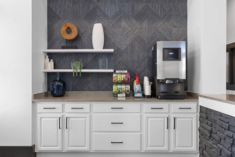 A kitchen with white cabinets and a grey backsplash.