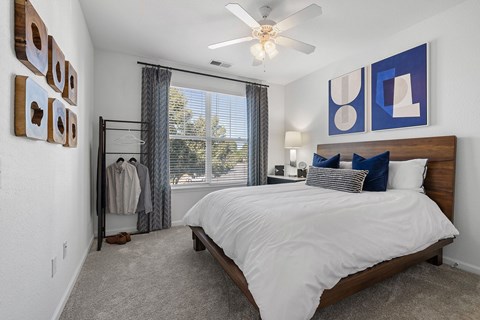 A bedroom with a large bed and a ceiling fan.
