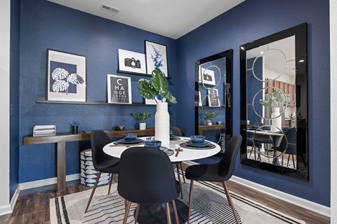 A dining room with a white table and chairs.