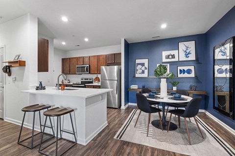 A modern kitchen with a dining table set for two.