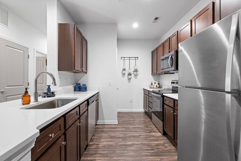 A modern kitchen with wooden cabinets and stainless steel appliances.