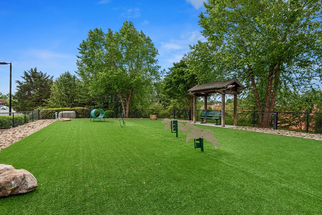 a gazebo sits at the end of a large grassy area