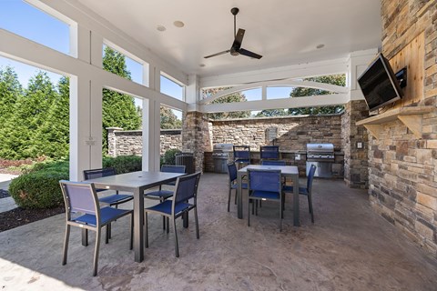 A patio with a table and chairs and a ceiling fan.