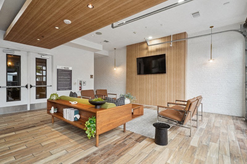 a lobby with a table and chairs and a television