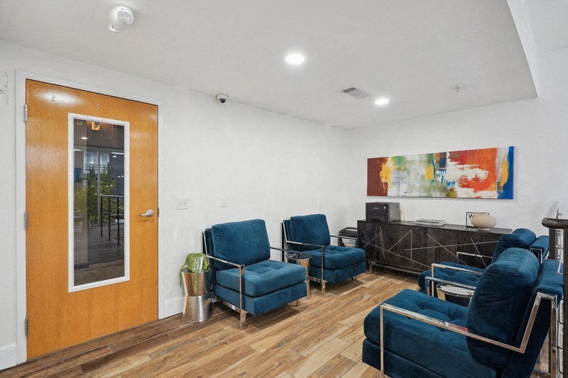 a living room with blue chairs and a wooden floor