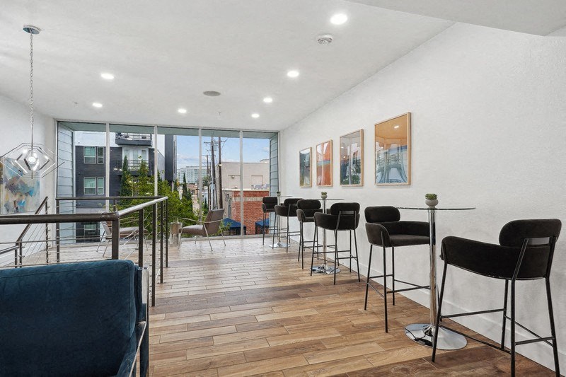 a room with bar stools and a view of the city