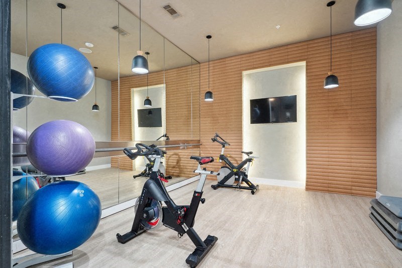 a gym with exercise bikes and a tv on the wall