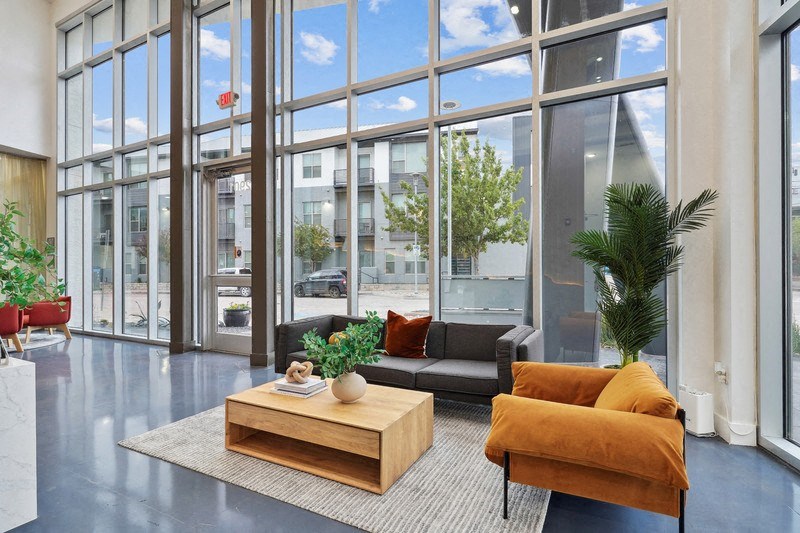 a living room with a couch and a coffee table in front of large windows