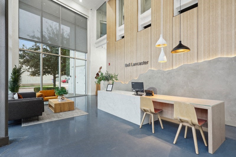 a home office with a desk and a large window