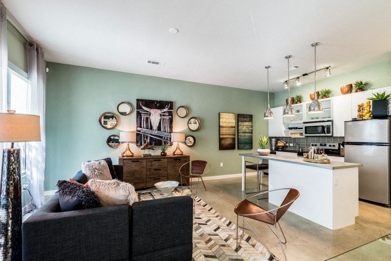 a living room with a couch and a kitchen with a sink