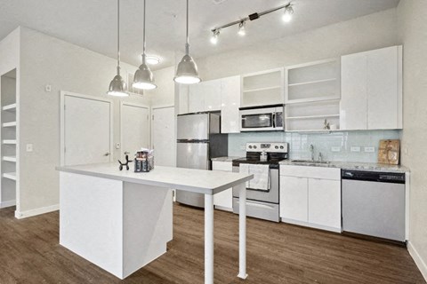 a kitchen with white cabinets and appliances and a white island
