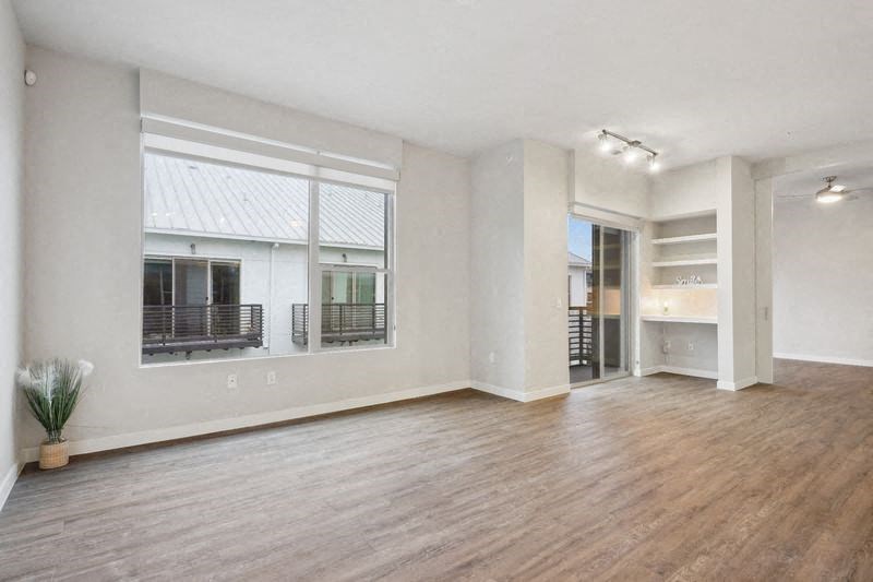 a living room with a large window and a wooden floor