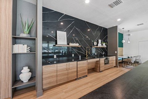 A modern kitchen with wooden cabinets and a marble backsplash.