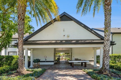 A white house with a black roof and a covered patio.