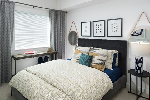 a bedroom with a bed and a dresser and a window