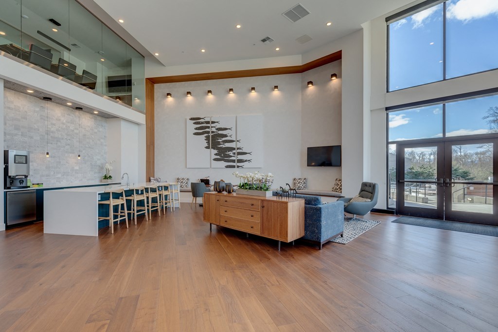 a living room with a dining room and a kitchen and large windows
