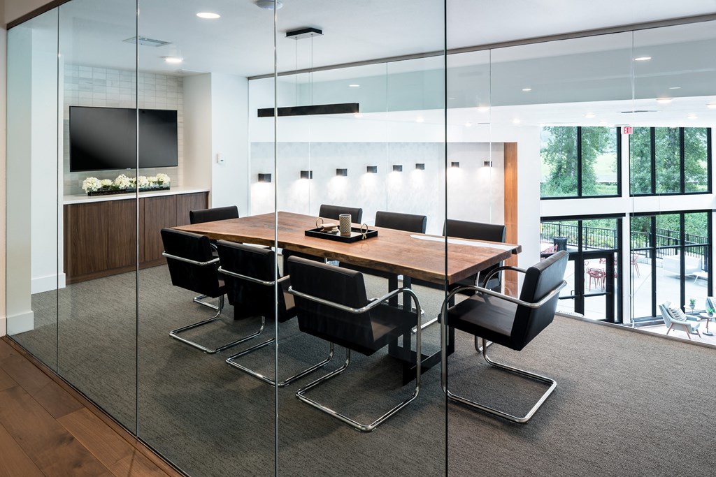 a conference room with a wooden table and black chairs