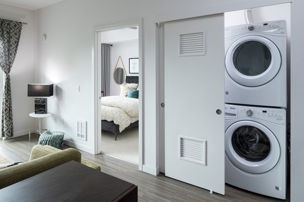a living room with a washing machine and a dryer in a door