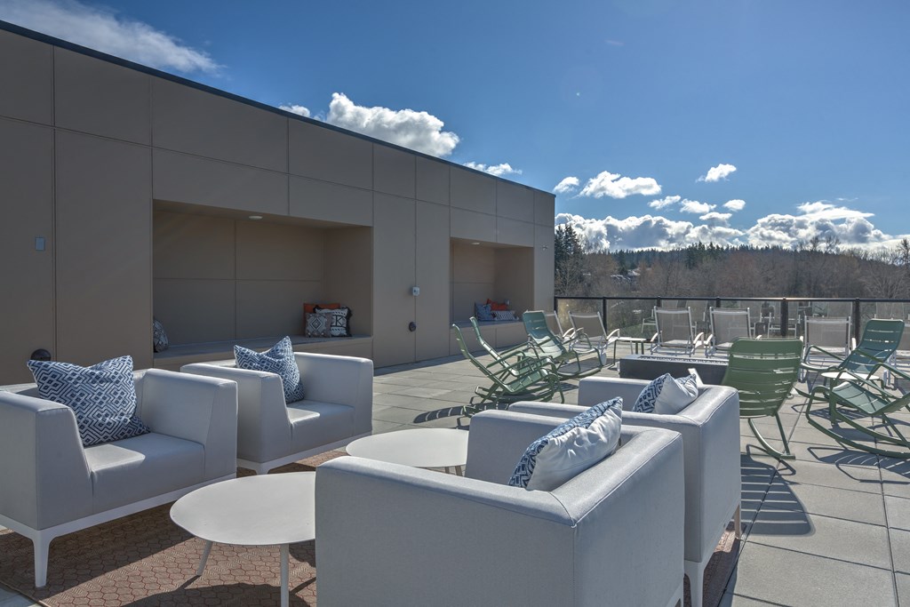 a terrace with chairs and couches and tables on a roof