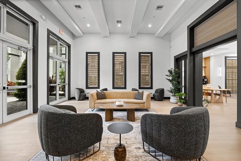 A modern living room with grey chairs and a brown coffee table.