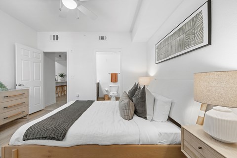 A bedroom with a large bed and a ceiling fan.