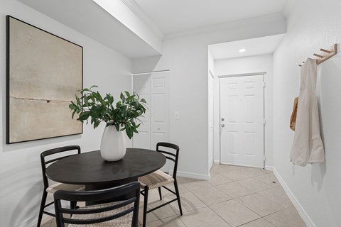 A dining room with a table and chairs.
