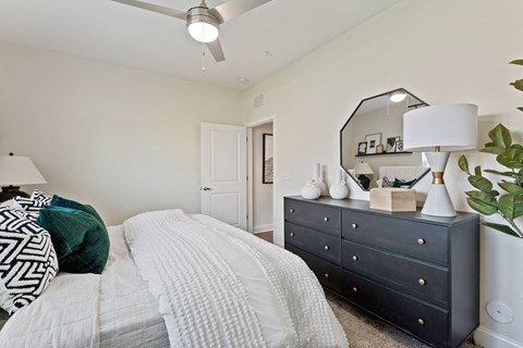 a bedroom with a bed and a dresser with a mirror