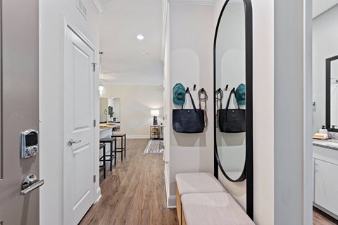 a hallway with a white door and a large mirror on the wall