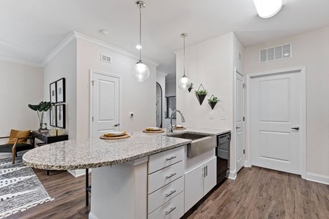 a kitchen and living room with white walls and wood flooring
