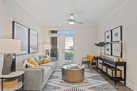 a living room with a grey couch and yellow accents