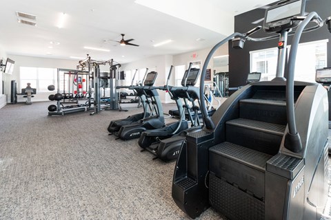 a large fitness room with cardio equipment and a treadmill