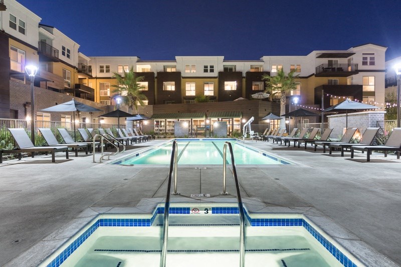 a swimming pool at night at the preserve at polo terrace apartments